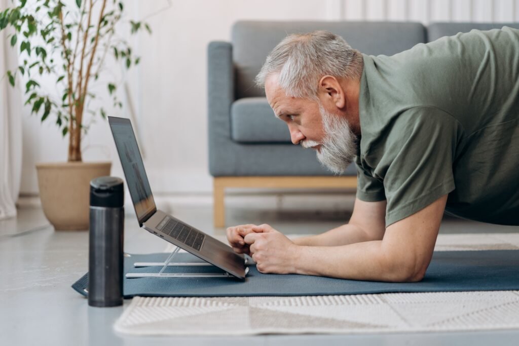 Older man doing a plank during an indoor senior fitness training workout at home